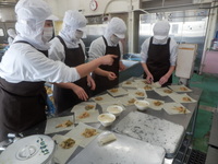 調理員さんが春巻きを包んでいる様子